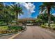 Gated entrance to a community with palm trees and lush landscaping at 15815 Muirfield Dr, Odessa, FL 33556