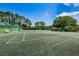 Two tennis courts with benches and surrounding trees at 15815 Muirfield Dr, Odessa, FL 33556