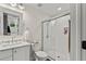 Modern bathroom with white shaker cabinets, marble countertops, and a large walk-in shower at 1707 E Park Cir, Tampa, FL 33610