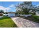 House with a paved driveway and a large tree in the front at 3102 57Th S St, Gulfport, FL 33707