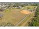 An aerial view of a baseball field with a dirt infield and chain-link fence at 509 Florida S Cir, Apollo Beach, FL 33572