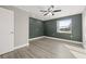 Bright bedroom with ceiling fan, wood-look floors, and a large window at 509 Florida S Cir, Apollo Beach, FL 33572