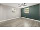 Bright bedroom with wood-look floors and two windows at 509 Florida S Cir, Apollo Beach, FL 33572