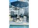 Relaxing pool area with patio furniture and umbrella at 6047 Twin Bridges Dr, Zephyrhills, FL 33541