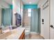 Bathroom with tub shower combo and teal colored walls at 613 Tanana Fall Dr, Ruskin, FL 33570