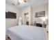 Cozy bedroom featuring a queen-size bed, a large TV, and a view into the bathroom at 613 Tanana Fall Dr, Ruskin, FL 33570