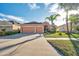 Two-story house with orange exterior, two-car garage, and green lawn at 613 Tanana Fall Dr, Ruskin, FL 33570