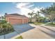 Two-story house with orange exterior, two-car garage and driveway at 613 Tanana Fall Dr, Ruskin, FL 33570