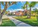 Two-story house on a tree-lined street with a two-car garage and palm trees at 613 Tanana Fall Dr, Ruskin, FL 33570