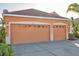Two-car garage with orange doors and white trim at 613 Tanana Fall Dr, Ruskin, FL 33570