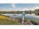 Calm lake view, showcasing neighborhood homes and a community sign at 613 Tanana Fall Dr, Ruskin, FL 33570
