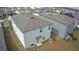 Rear view of two story house with gray siding and gray roof at 6300 Beverly Hills Dr, Zephyrhills, FL 33541