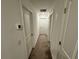 Bright hallway with neutral colored carpet and doors to bedrooms at 6300 Beverly Hills Dr, Zephyrhills, FL 33541