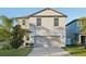 Two-story house with gray siding, two-car garage, and landscaping at 7402 Evening Primrose Ct, Tampa, FL 33619