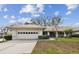Single-story home with attached garage and landscaped lawn at 9214 Golf View Dr, New Port Richey, FL 34655