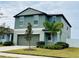 Two-story house with green exterior, two-car garage, and landscaping at 13621 Willow Bluestar Loop, Riverview, FL 33579