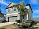 Two-story house with a two-car garage and landscaped lawn at 13621 Willow Bluestar Loop, Riverview, FL 33579