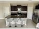 Modern kitchen with granite countertops and dark wood cabinets at 13621 Willow Bluestar Loop, Riverview, FL 33579