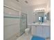 Clean bathroom with walk-in shower, white vanity, and blue accents at 2438 Sifield Greens Way # 44, Sun City Center, FL 33573