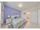 Main bedroom, lavender walls, white bedding, ensuite bathroom at 2438 Sifield Greens Way # 44, Sun City Center, FL 33573