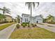 House exterior showcasing a light blue color scheme, landscaping and driveway at 2438 Sifield Greens Way # 44, Sun City Center, FL 33573