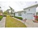 Light blue house exterior with attached garage and well-manicured landscaping at 2438 Sifield Greens Way # 44, Sun City Center, FL 33573