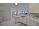 Open kitchen, white cabinets, breakfast bar, white appliances at 2438 Sifield Greens Way # 44, Sun City Center, FL 33573