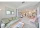 Bright living room with light green sofa and view into dining area at 2438 Sifield Greens Way # 44, Sun City Center, FL 33573