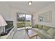 Living room with green sofa and sliding glass doors to patio at 2438 Sifield Greens Way # 44, Sun City Center, FL 33573
