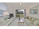 Living room with green sofa and sliding glass doors to patio at 2438 Sifield Greens Way # 44, Sun City Center, FL 33573