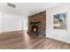 Living room featuring a brick fireplace and hardwood floors at 25888 Whipperwill St, Brooksville, FL 34601