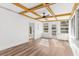 Sunroom with hardwood floors, white walls, and yellow ceiling beams at 25888 Whipperwill St, Brooksville, FL 34601