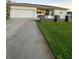 Clean driveway leading to a white house with a garage at 289 Monte Cristo Blvd, St Petersburg, FL 33715