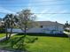 White house with gray roof, green lawn, and palm trees at 289 Monte Cristo Blvd, St Petersburg, FL 33715