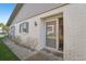 Front entrance with gray door and white brick facade at 3340 Mcmath Dr, Palm Harbor, FL 34684