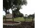Highland Lakes Golf Club entrance with bench and trees at 3340 Mcmath Dr, Palm Harbor, FL 34684