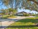 Landscaped front yard with circular driveway and mature trees at 4098 Las Palmas Way, Sarasota, FL 34238
