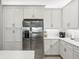 Modern kitchen with white cabinets and stainless steel appliances at 4719 Avila Lakes Dr, Wimauma, FL 33598