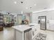 Open concept kitchen with island, stainless steel appliances, and view of dining area at 4719 Avila Lakes Dr, Wimauma, FL 33598