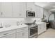 Modern kitchen with white cabinets, gas stove, and stainless steel appliances at 4719 Avila Lakes Dr, Wimauma, FL 33598