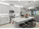 Modern kitchen with white cabinets, stainless steel appliances and large island at 4719 Avila Lakes Dr, Wimauma, FL 33598