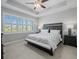 Large bedroom with king bed, window seating and ceiling fan at 4719 Avila Lakes Dr, Wimauma, FL 33598