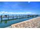 Long wooden dock extending to the water with chairs at 5176 Se Salmon Se Dr # D, St Petersburg, FL 33705