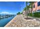 Brick-paved waterfront pathway with palm trees and a flag at 5176 Se Salmon Se Dr # D, St Petersburg, FL 33705