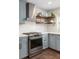 Modern kitchen features floating shelves, stainless steel appliances, and hexagon tile backsplash at 5321 Dover Ne St, St Petersburg, FL 33703