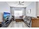 Cozy living room features a large sectional sofa, media center, and a ceiling fan at 10601 Shady Falls Ct, Riverview, FL 33578