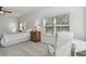 Bright main bedroom with carpeted floor, large windows, and a work area at 10883 Dragonwood Dr, Tampa, FL 33647