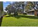 Spacious backyard with lush grass and mature trees at 11411 Turtle Dove Pl, New Port Richey, FL 34654
