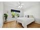 Bedroom with wood floors, large window, and ceiling fan at 11411 Turtle Dove Pl, New Port Richey, FL 34654