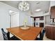 Bright dining area with wood table and chandelier, adjacent to kitchen at 11411 Turtle Dove Pl, New Port Richey, FL 34654